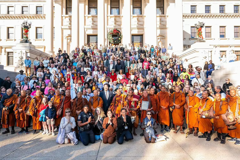 Aloka the Peace Dog with Buddhist monks and community gathered at a peace event